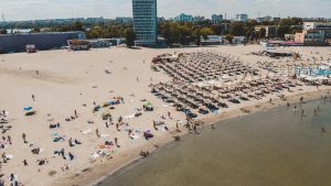 Stunning aerial shot of a lively beach in Constanța, Romania, with sunbathers and umbrellas.